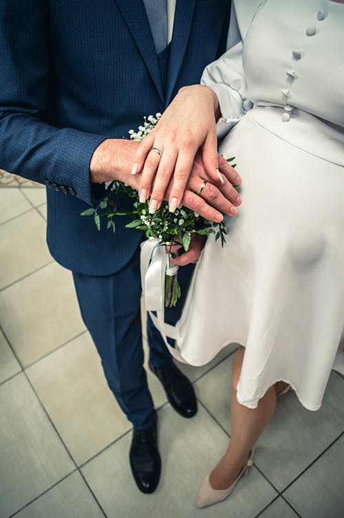 A Person in White Dress Standing beside a Person in Blue Suit