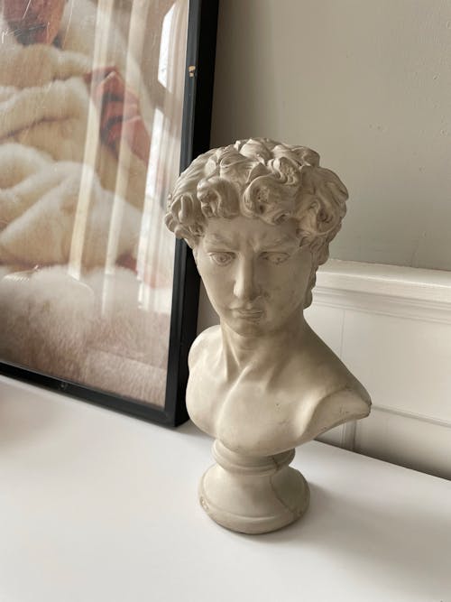 Free White Face Sculpture near the Wooden Picture Frame  Stock Photo