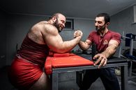 Man in Red and Black Striped Shorts Sitting on Black Table