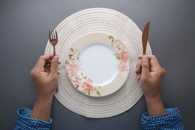 Man Hands With Knife And Fork Over Empty Plate