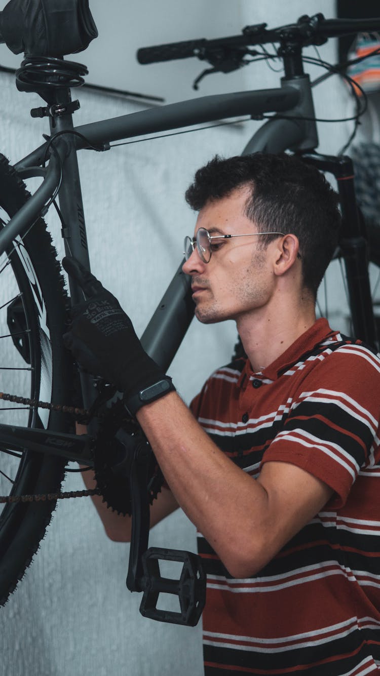 Man Fixing A Bicycle In Gloves