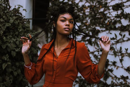 Woman in Orange Long Sleeve Shirt Holding her Hair