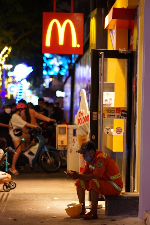 Man Sitting Outside a Fast Food Chain