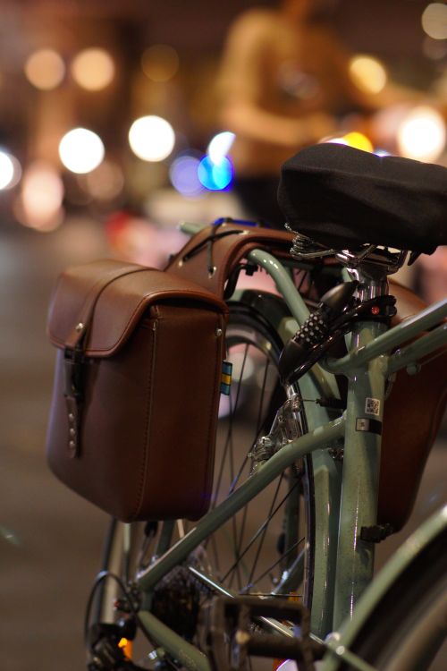Free Close-up of a vintage bicycle with leather panniers on a city street at night. Stock Photo