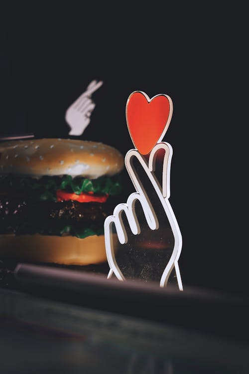 Neon Hand Holding Heart near Hamburger