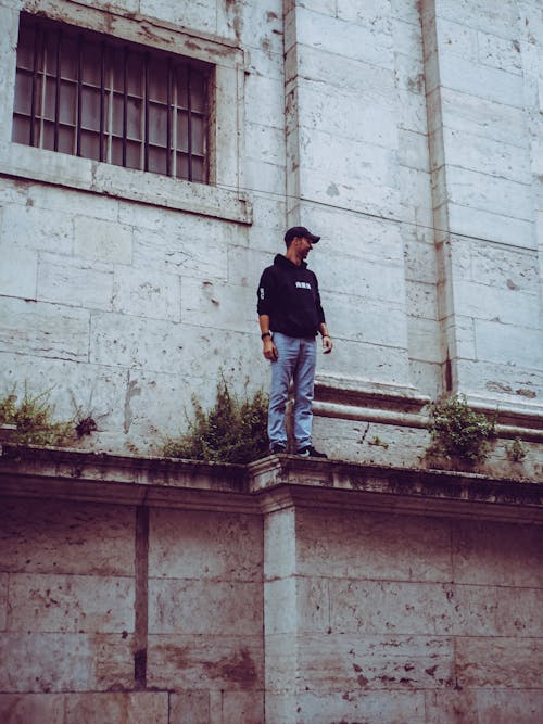 Man in Black Hooded Jacket Standing on Edge