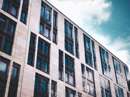 Free Modern apartment building facade with glass windows against a blue sky in Frankfurt. Stock Photo