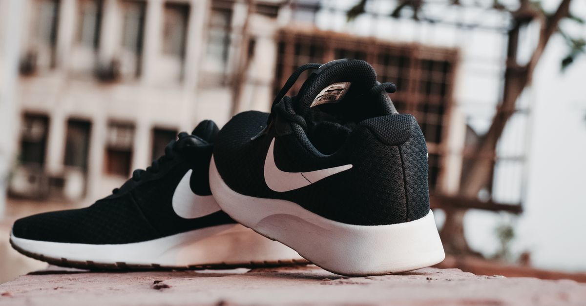 Close-up of black sneakers on urban pavement in New Delhi, India.