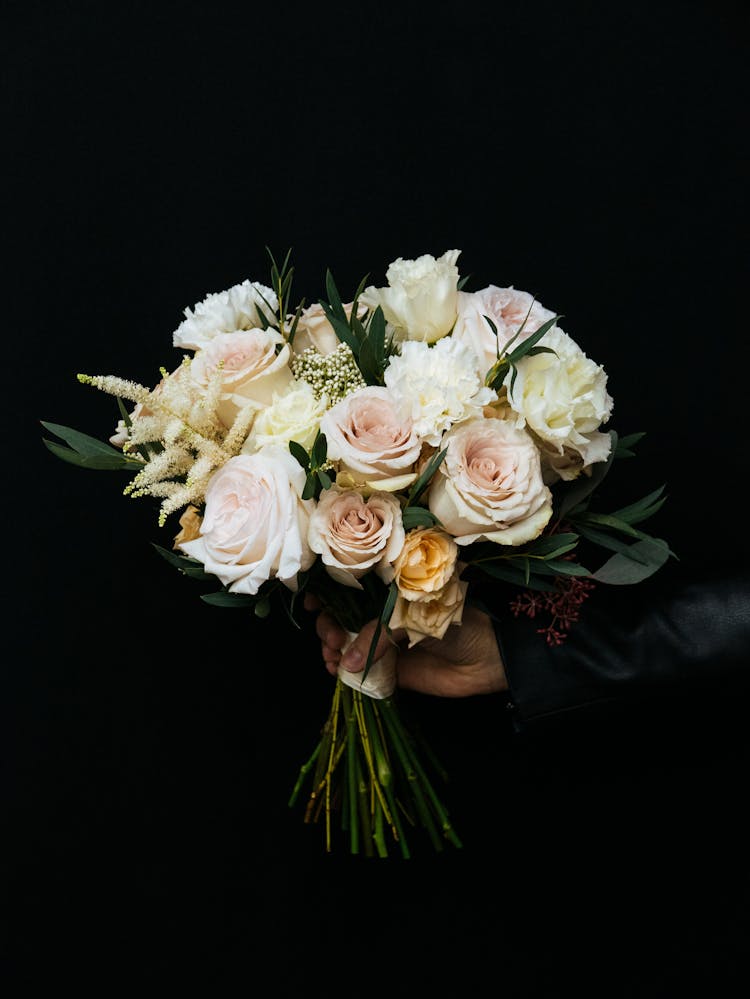 Hand Holding Bouquet Of Roses