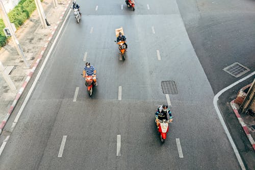 People Riding on Red and Black Sports Bike on Road
