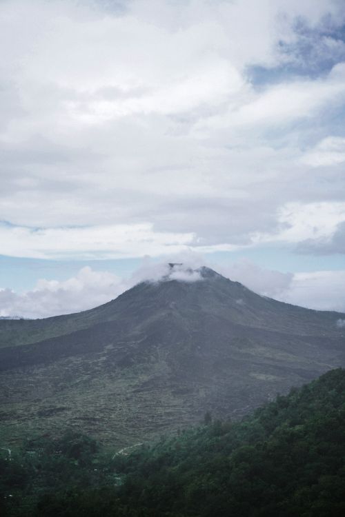 Free Serene view of Mount Batur's peak surrounded by clouds and lush greenery, showcasing Bali's natural beauty. Stock Photo