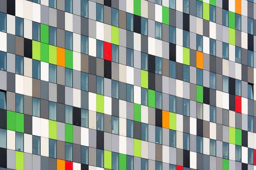 Vibrant geometric facade featuring multicolored panels and windows in a modern architectural design.