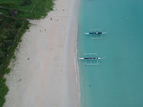 Free Stunning aerial view of traditional boats on the turquoise waters of Araceli beach, Philippines. Stock Photo