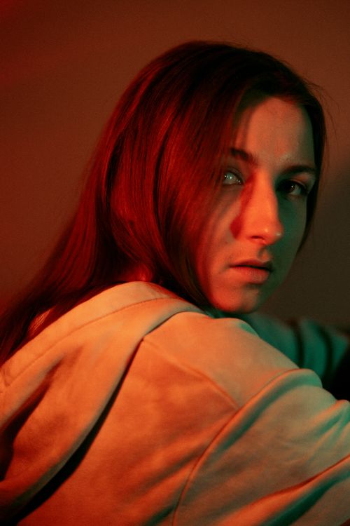 Free Close-up portrait of a woman in soft lighting, creating a moody atmosphere. Stock Photo