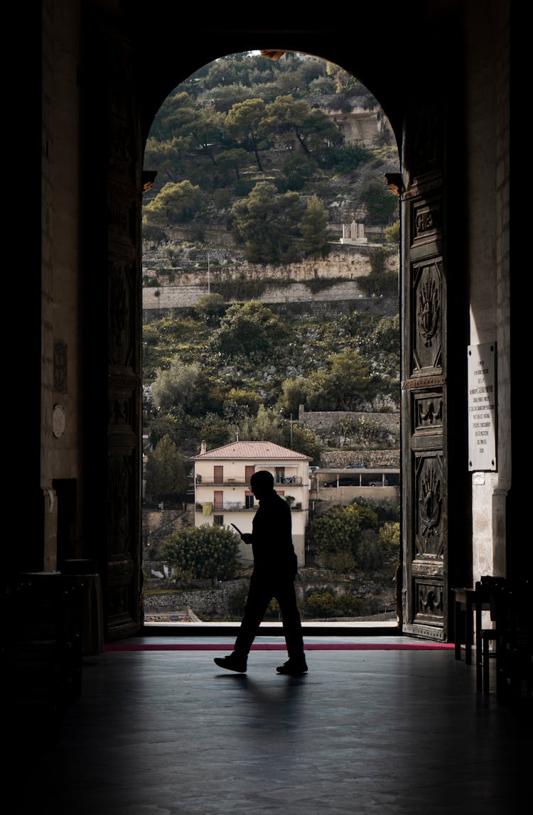 Silhouette Of A Person Walking Near A Door