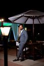 Man in Black Suit Standing Near Table