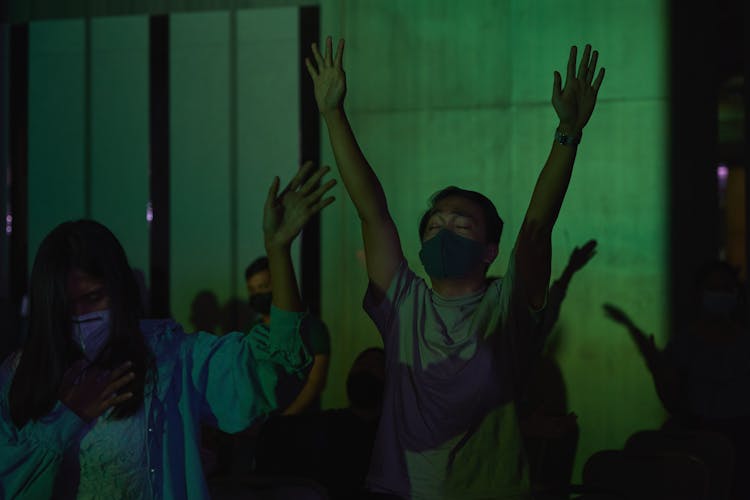 Man And A Woman Raising Their Hands