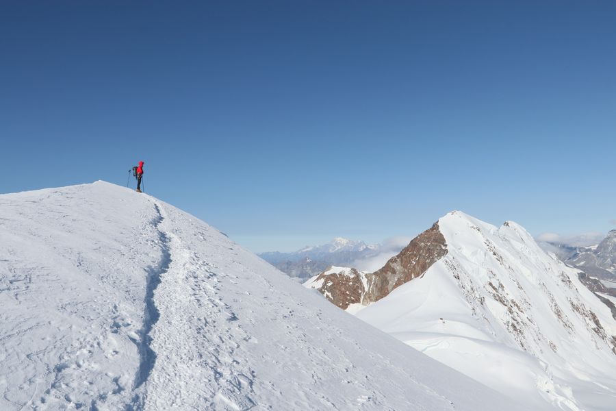 A lone climber on a snow-covered peak