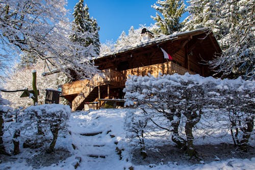 A Wooden House Surrounded with Snow During Winter Season