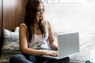 Woman Sitting on Couch With Macbook Pro on Lap