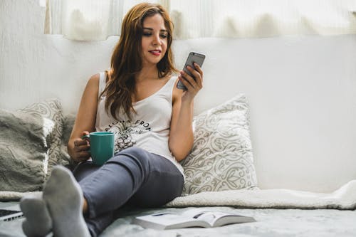 Vrouw Met Kopje Dragen Tank Top Zittend Op Bed