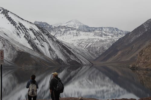 Two Man and Girl Looking at Snow Filled Mountains
