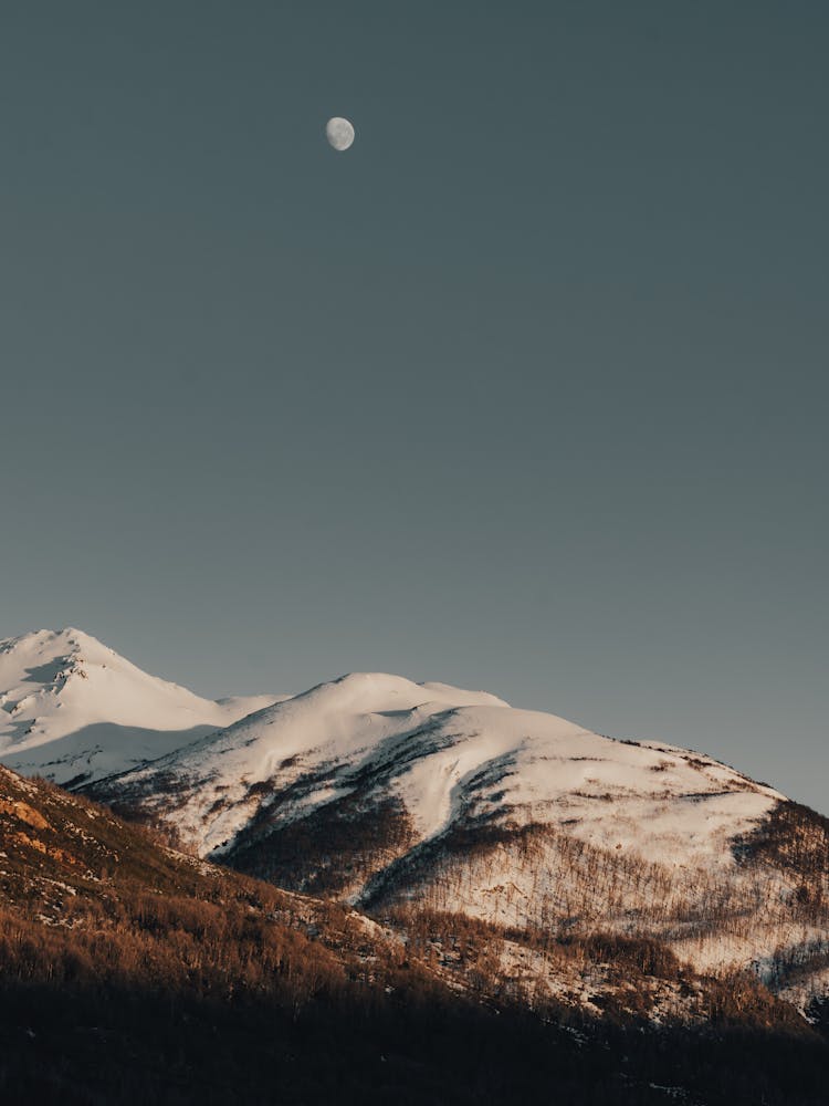 Snowcapped Mountain And Moon On Clear Sky 