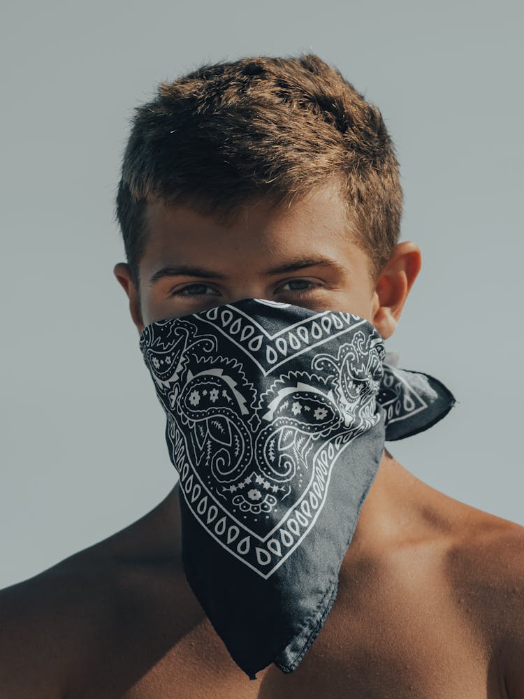 A Shirtless Man With A Bandana Face Mask