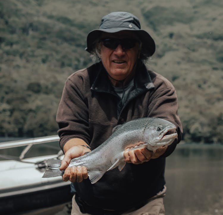 Photo Of A Man Holding A Trout Fish