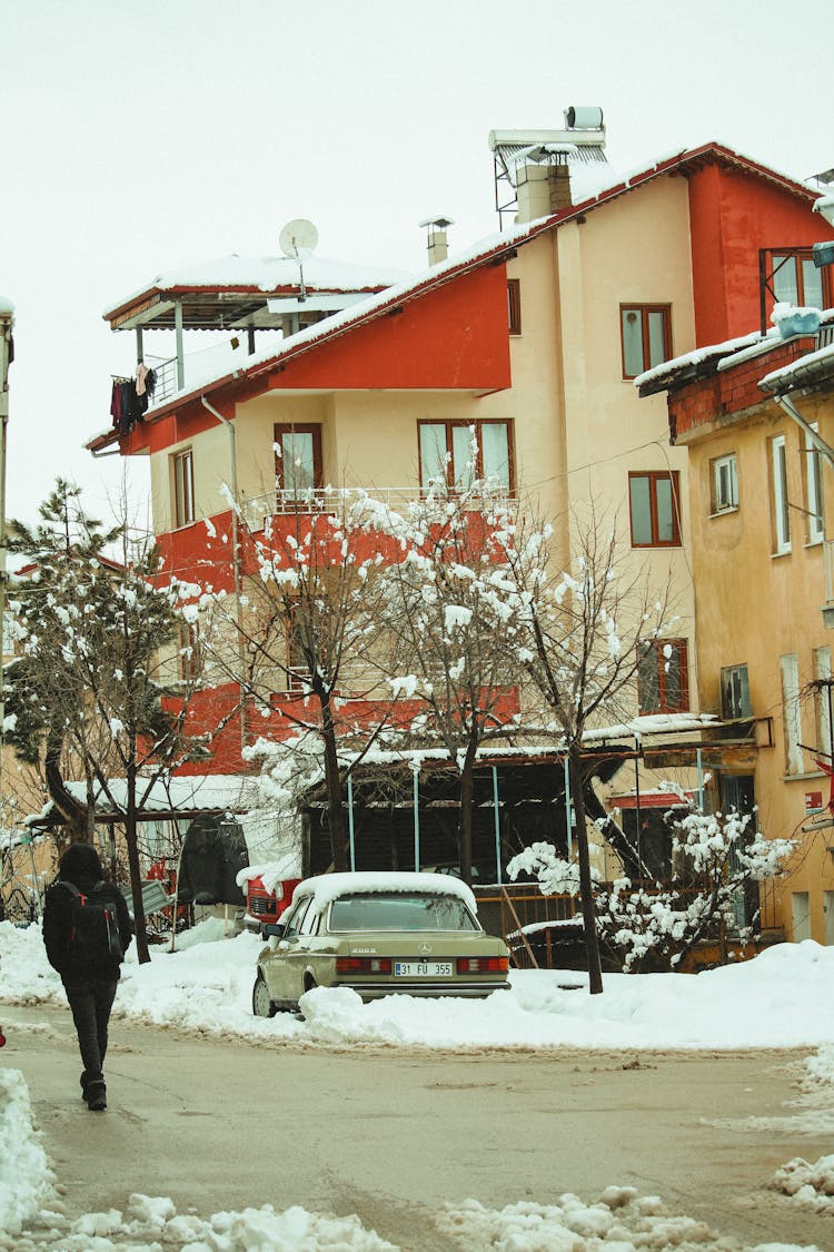 Back View Of A Person Walking Near Parked Car 