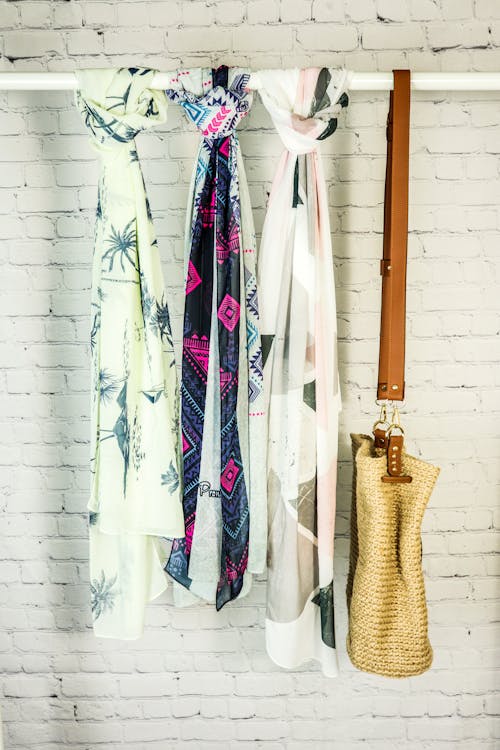 Assorted Scarves and a Shoulder Bag Hanging on a Rod