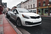 White Kia Car Parked on the Side of the Road