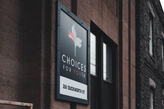 Close-up of Choices for Youth sign on urban building at 261 Duckworth St.