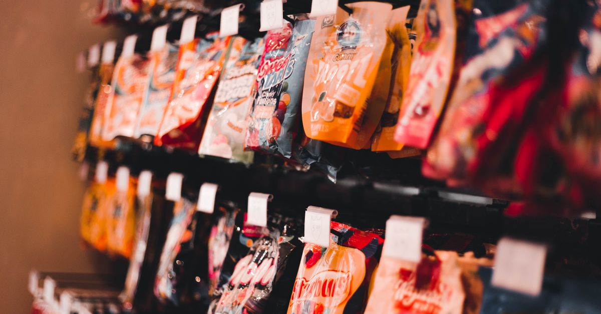 a person standing in a candy shop looking overwhelmed by choices, but happy