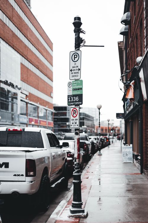 Free Wet urban street scene with cars and buildings in the background on a rainy day. Stock Photo
