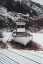 A White and Red Boat Hauled on Snow Covered Ground During Winter