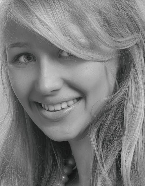 Grayscale Photo of Woman Smiling