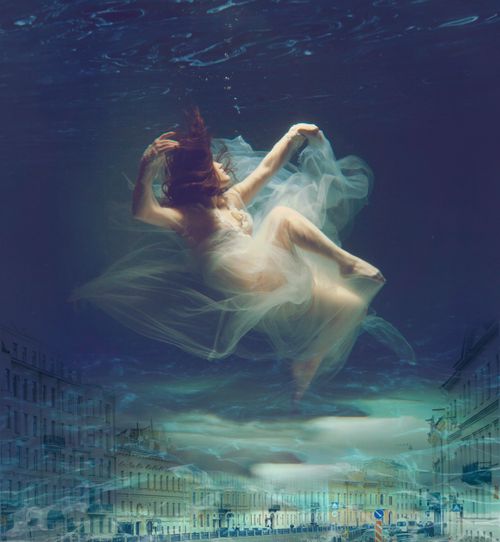 Free Artistic underwater scene of a woman in a flowing dress, blending with city street elements. Stock Photo