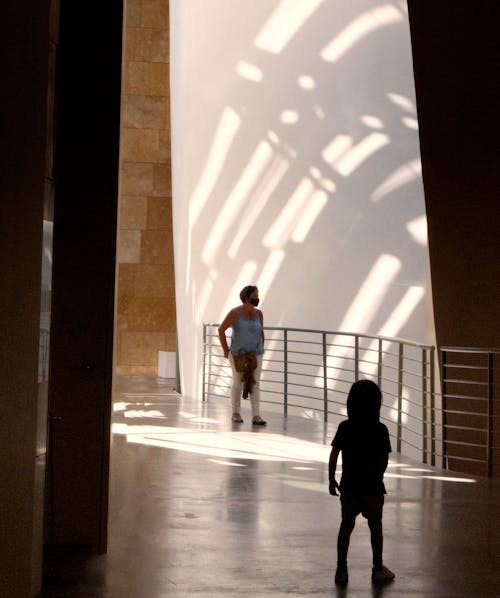 Child and Woman in Empty Corridor of Art Gallery