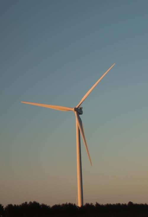 Free A White Wind Turbine Under Blue Sky Stock Photo