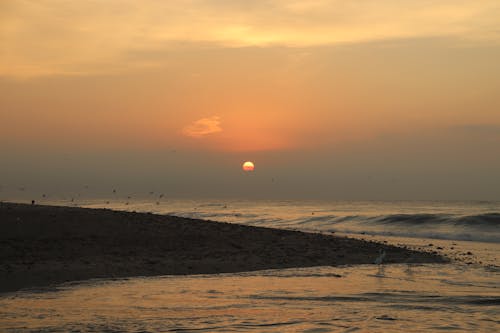 Scenic View of Ocean Waves Crashing on Shore during Sunset