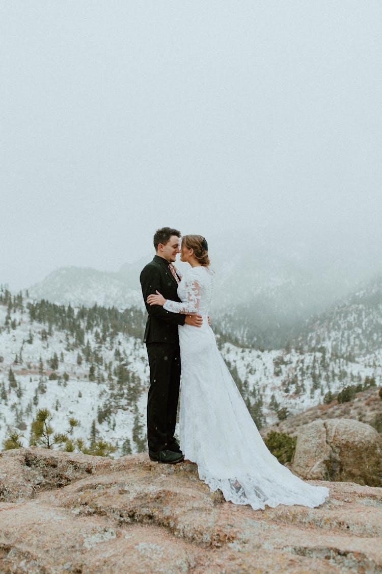 Bride And Groom Kissing On Brown Rock