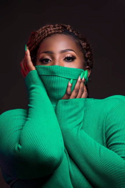 Stunning portrait of a woman with captivating eyes and vibrant green sweater, exuding elegance and style.