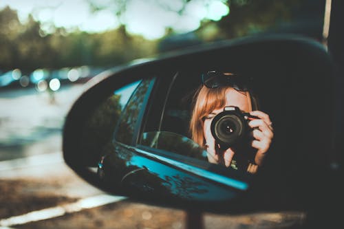 무료 거울을 통해 카메라를 복용하는 여자의 선택적 초점 사진 스톡 사진