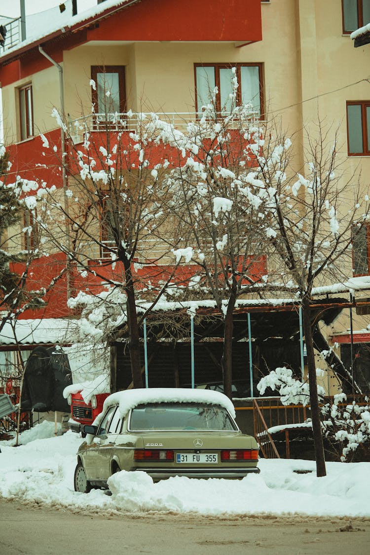 Snow Covered Car Near A Building