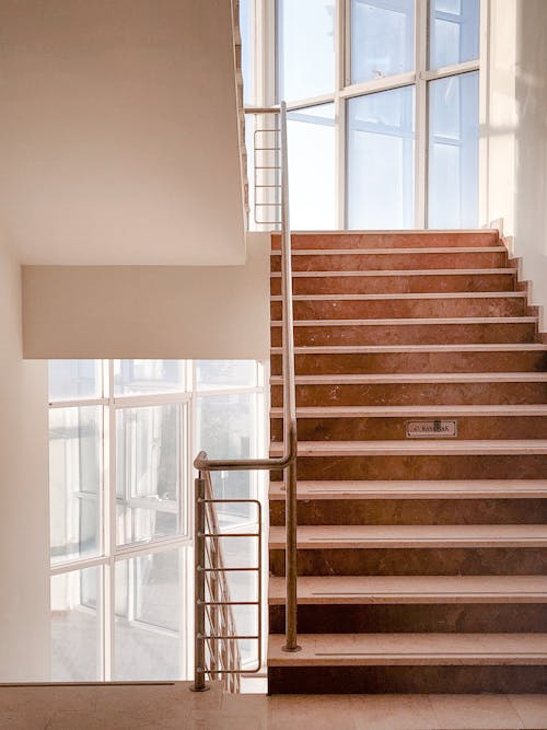 Concrete Staircase with Metal Railings Near the Glass Window