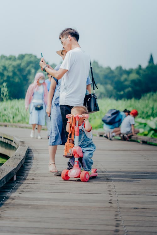 Free A Family Standing on the Wooden Footpath Stock Photo