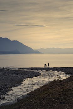 Couple walking along the scenic shores of Lake Maggiore at dusk, offering a tranquil view of the Italian landscape.