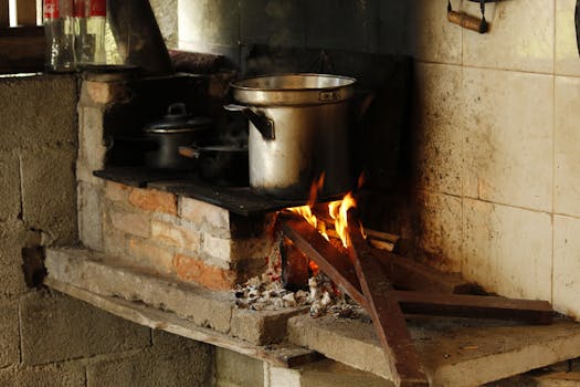 Traditional cooking setup with a wood fire stove in a rustic kitchen setting.