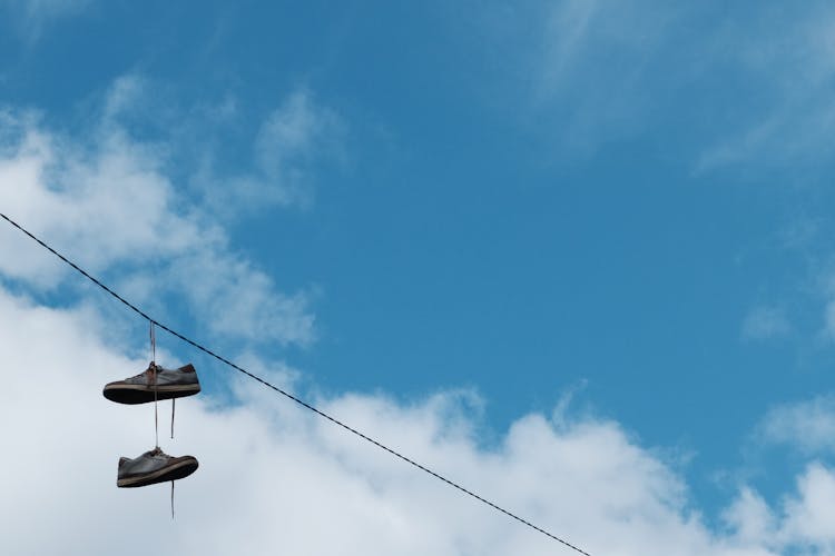 Shoes Hanging On A Line Against Blue Sky 